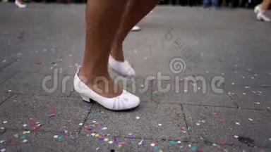 在<strong>国庆</strong>节期间，穿着白色鞋子在街上跳舞的男人和女人的腿都闭上了。 艺术。 西班牙